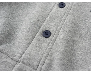 Macro detail of gray knitted jacket featuring dark blue buttons and soft fleece texture