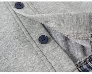 Detailed macro view showing the gray knit fabric, navy buttons, and plaid lining