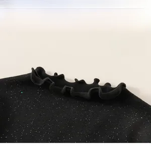 Close-up of girls black knitted top showing glittering fabric and ruffled neckline