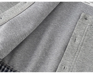Detail of grey knitted fabric texture with buttonholes and plaid lining accents