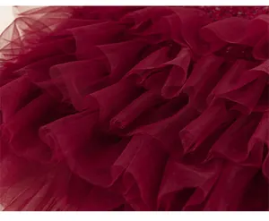 Detailed close-up of dark red layered mesh tulle skirt showing soft texture and ruffles