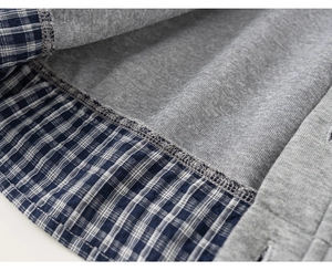 Detail of soft grey knit lining and blue plaid trim with professional overlock stitching