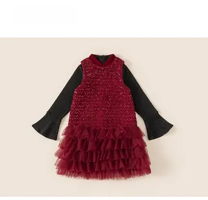 Detail of red festive girl's dress featuring sequined bodice and tiered mesh tulle skirt