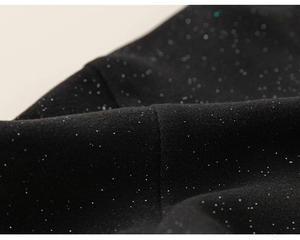 Detailed macro view of black fabric with sparkling silver sequins and glitter texture