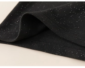 Detailed view of black sequined fabric with silver glitter and fine stitching craft
