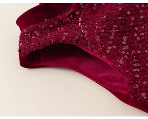 Detail of red festive dress with sparkling sequins and thick fleece lining for girls
