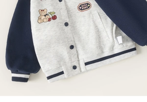 Detailed close-up of kids' varsity jacket featuring bear embroidery and logo badge