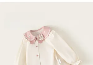 Detail of baby girl cotton shirt with pink Peter Pan collar and cartoon bunny embroidery
