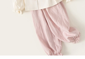 Detail of cream doll collar shirt and pink pants with floral embroidery for girls