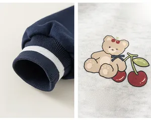 Detail of ribbed navy cuffs and cute cartoon bear print on gray fabric for kids' jacket