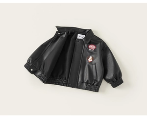 Close-up of black kids leather jacket featuring cartoon dog patch and ribbed cuffs