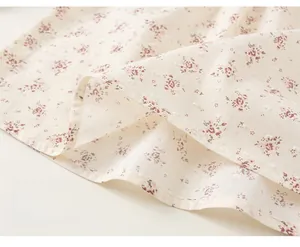Dettaglio del tessuto floreale per vestito da bambina con pois e orlo ampio