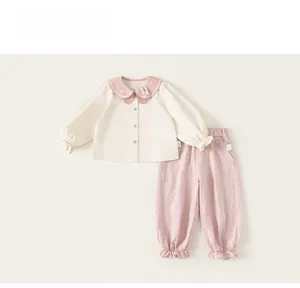 Detail of girl cotton set showing doll collar with embroidery and lace hem on trousers