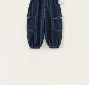 Detail of dark blue denim cargo pants showing elastic waistband and side pocket buttons