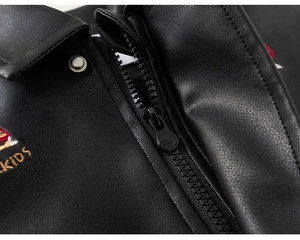 Macro shot of children's black faux leather jacket featuring KIDS embroidery and metal zipper