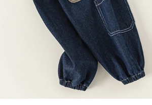 Close-up of boys deep blue denim joggers with white contrast stitching and elastic cuffs