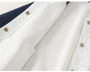 Macro detail of navy baseball jacket showing warm fleece lining and metal snap button