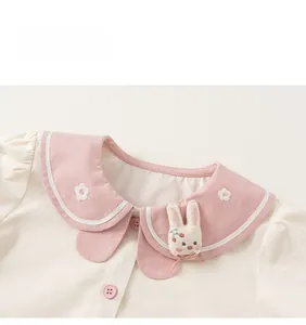 Detail of pink Peter Pan collar with flower embroidery and cute rabbit decor on kids top