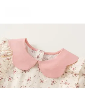 Dettaglio del colletto Peter Pan rosa e tessuto di cotone floreale su vestito da bimba