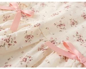 Dettaglio ravvicinato del tessuto floreale con pois jacquard e fiocchi di raso rosa