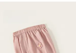 Detail of pink cotton toddler pants featuring elastic waistband and floral embroidery decoration