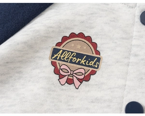 Detail of kids baseball jacket featuring the embroidered Allforkids badge and soft fabric texture