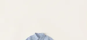 Close-up of blue and white plaid shirt collar with a white button and soft cotton texture