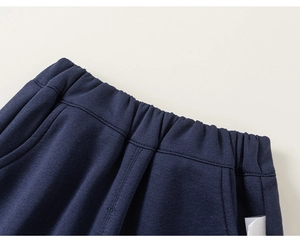 Detail of boys navy blue knit cotton trousers with elastic waistband and side pockets