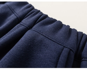 Close-up of boys deep blue knitted cotton elastic waistband with precise stitching details