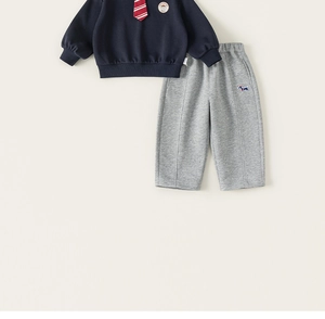 Détail du sweat-shirt bleu marine pour garçon avec cravate et pantalon gris brodé