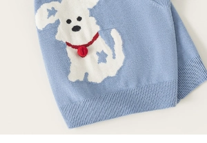 Detail of light blue knit sweater with white jacquard puppy and red 3D pom-pom