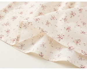 Dettaglio ravvicinato del tessuto floreale con piccoli fiori rosa e trama a pois svizzeri