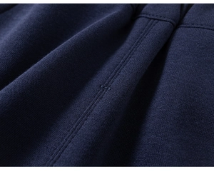 Macro shot of navy blue knit fabric showing fine texture and reinforced stitching detail