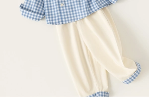 Detailed flat lay of boys' plaid shirt and beige casual pants with matching checkered cuffs