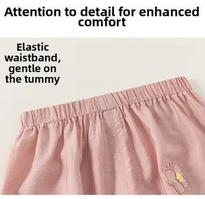 Detailed macro view of pink cotton baby trousers with elastic waistband and butterfly patch