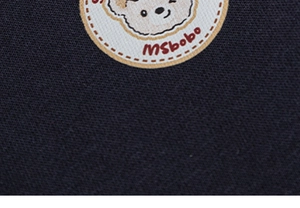 Détail d'un écusson ours mignon avec texte MSbobo sur un sweat-shirt pour enfant bleu marine