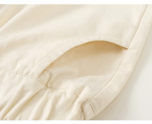 Detail of boys beige cotton twill pants showing side pockets and elastic waistband