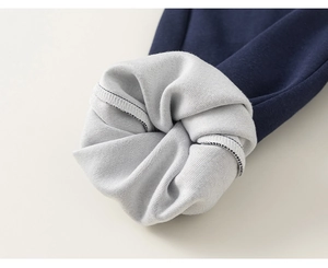 Detail of navy blue knit fabric with thick grey fleece lining and neat stitching