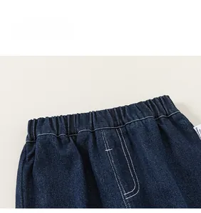 Detail of boys denim cargo pants featuring elastic waistband with white double stitching