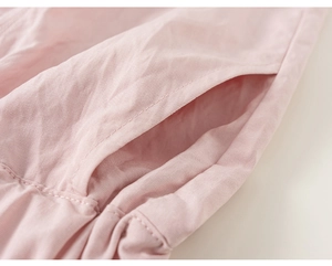 Detail of light pink kids' outfit featuring clean side pocket stitching and soft fabric