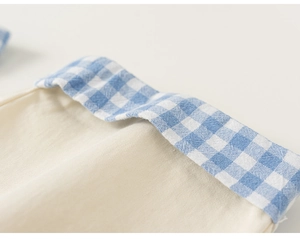 Macro detail of breathable cotton fabric with blue gingham trim on children's shirt