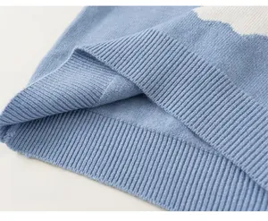 Close-up of sky blue knit sweater ribbed hem with decorative white wave pattern