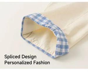 Detail of children's cotton pants featuring blue plaid patchwork on beige fabric hem