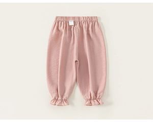 Detail view of pink girls' cotton trousers featuring wide elastic waistband and ruffled hems