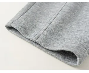 Vue détaillée des poignets de pantalon en maille grise avec double couture de finition