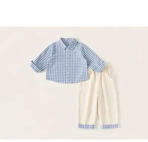 Detail of plaid cotton shirt and beige pants set with matching rolled cuffs