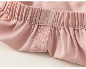 Detailed view of elastic waistband and stitching on pink cotton pants for girls