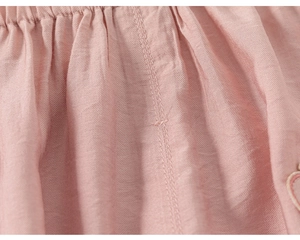 Detail of pink cotton fabric showing elastic waistband and neat double needle stitching