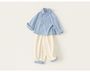 Detail of boys' blue plaid shirt and beige cotton pants with matching checkered cuffs