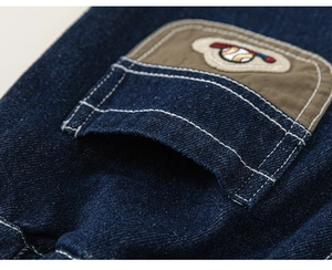 Detailed close-up of boy's denim jeans featuring khaki pocket and baseball embroidery
